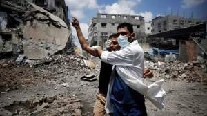 A medic helps a Palestinian in the Shejaia neighbourhood, which was heavily shelled by Israel during fighting, in Gaza City