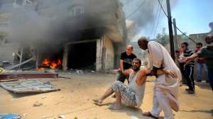 Palestinians evacuate a wounded man following what police said was an Israeli air strike on a house in Rafah in the southern Gaza Strip