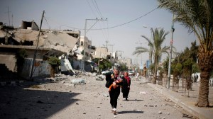A Palestinian woman arrives to look at her house in Beit Hanoun town